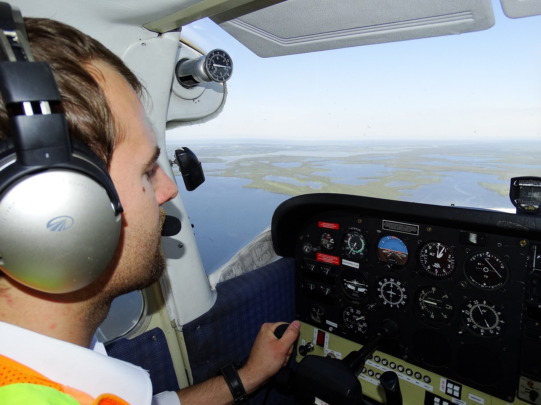 Young pilot at the controls of a Cessna over the water